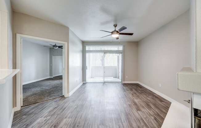 a living room with hardwood floors and a ceiling fan