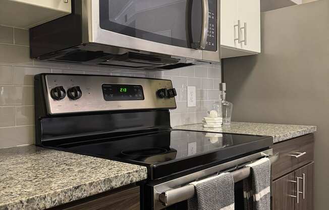 A modern kitchen with a black stove top oven and microwave above it.