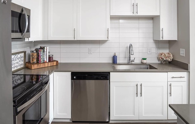 a white kitchen with stainless steel appliances and white cabinets