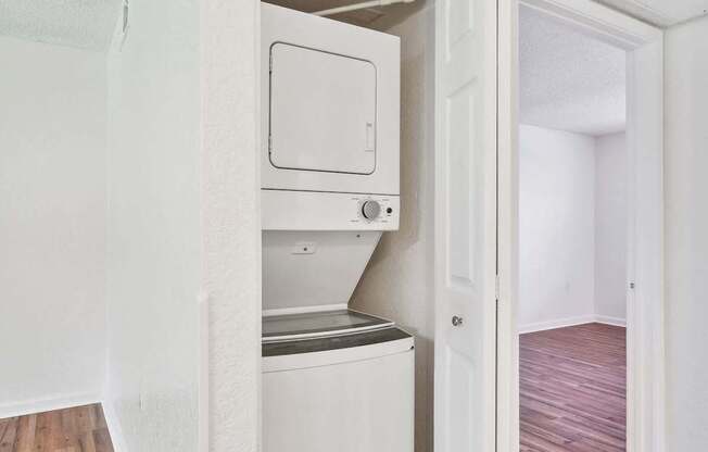 A white door is open to a small kitchen.