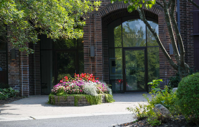 the front of a building with a flower garden in front of it