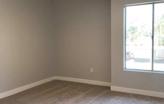 an empty room with a ceiling fan and a window