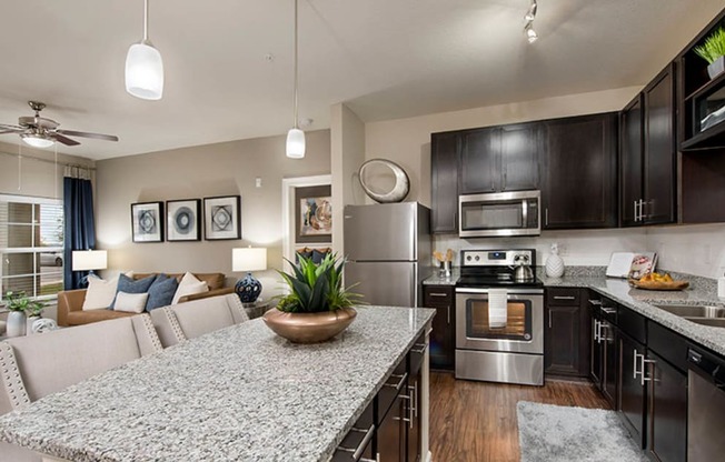 a kitchen and living room with a granite counter top