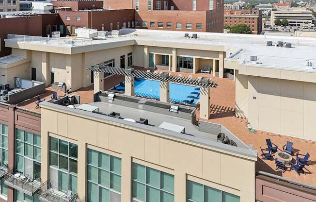 A rooftop with a pool and loungers.
