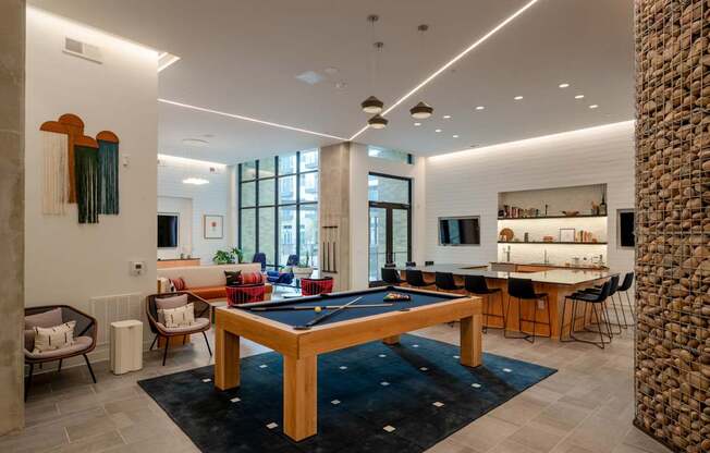 A room with a pool table and a stone pillar.