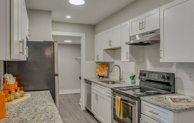 a kitchen with white cabinets and stainless steel appliances