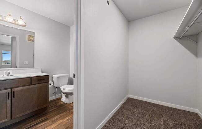 A bathroom with a toilet, sink, and mirror.