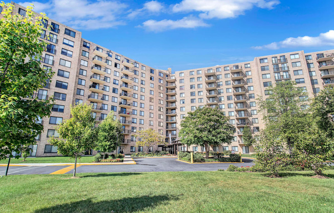 A large apartment complex with a grassy area in front.