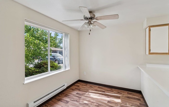 A room with a ceiling fan and a window.