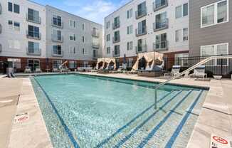 A swimming pool in front of apartment buildings.