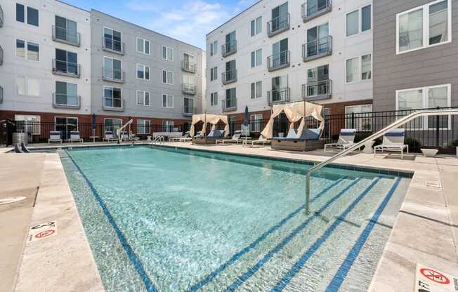 A swimming pool in front of apartment buildings.