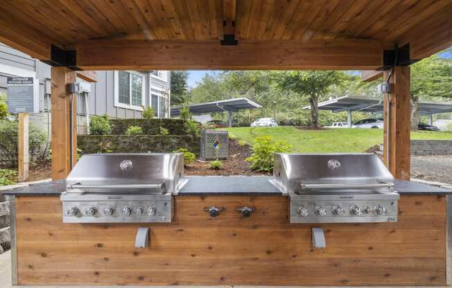 a covered outdoor grill area with two stainless steel appliances