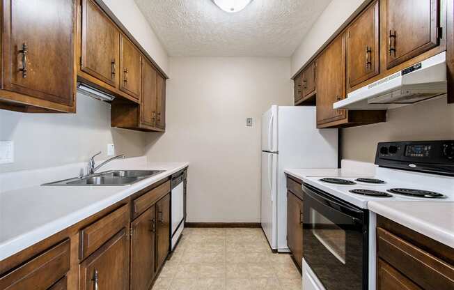 Omaha, NE Maple Ridge Apartment. A kitchen with white countertops and wooden cabinets