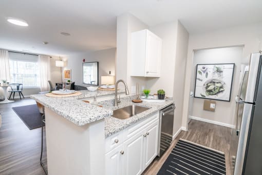 the view from the top of the stairs looking down into the living room and kitchen at Merion Milford Apartment Homes, CT, 06460