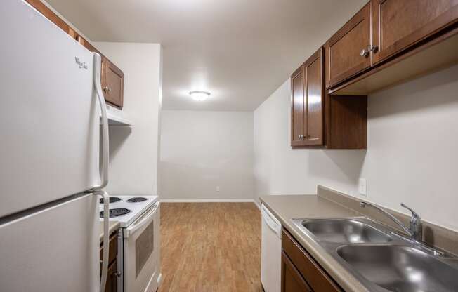 a kitchen with stainless steel appliances and wooden cabinets and a white stove and refrigerator