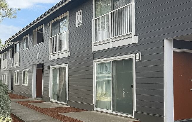 A grey building with red doors and windows.
