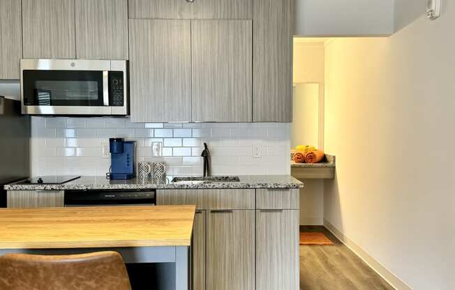 a kitchen with a island and a stove and a microwave at The Teale Navy Yard, North Charleston, 29405