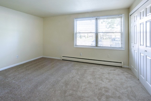 an empty room with carpet and a window