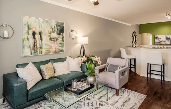 Stylish living room with sofa, accent chair, artwork, and glass coffee table