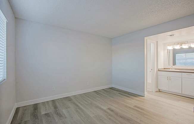 an empty bedroom with white walls and a bathroom