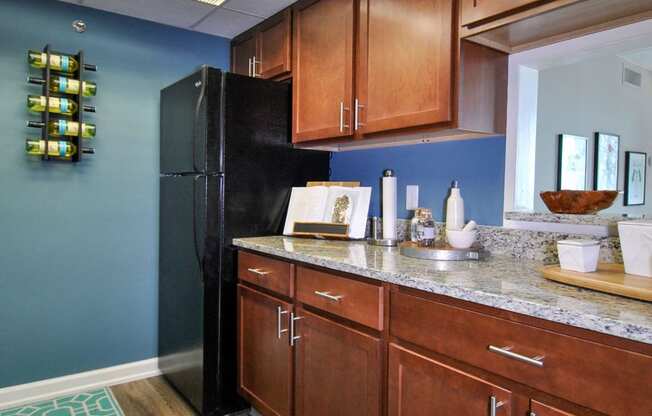 a kitchen with wooden cabinets and a black refrigerator