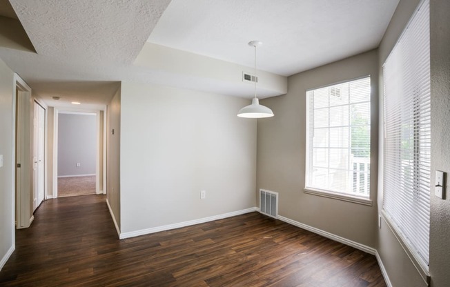 an empty living room with wood flooring and a large window