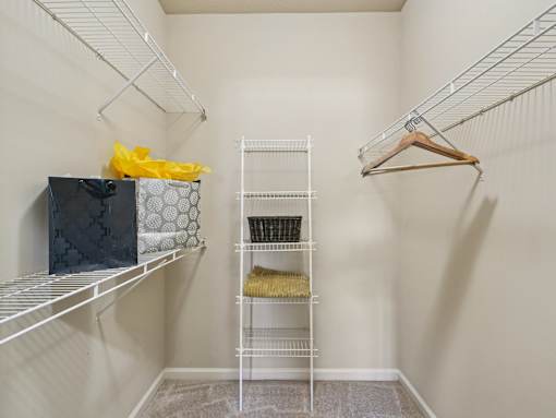 Spacious walk-in closet with built-in storage at Village at Broadstone Station apartments in Apex, NC