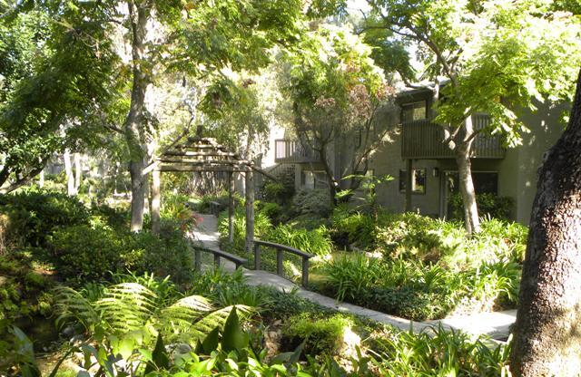 a apartment in the middle of a lush green garden