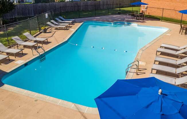 a swimming pool with chairs and umbrellas around it