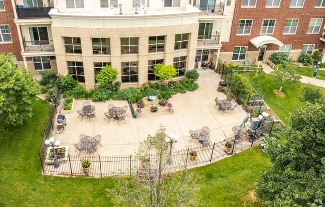 a courtyard with tables and chairs in front of a building