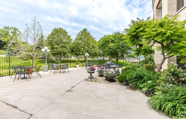 an outside patio with tables and chairs and plants and trees