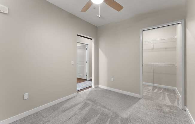 A room with a ceiling fan and a carpeted floor.