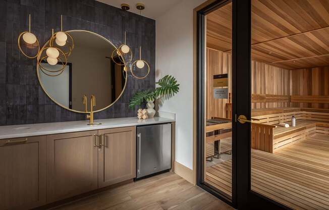A bathroom with a round mirror and a wooden floor.