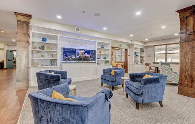 the lobby of a spa with blue chairs and a fish tank