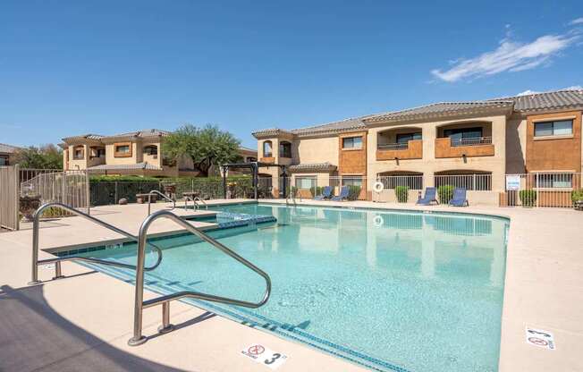 A swimming pool with a diving board in front of a building.