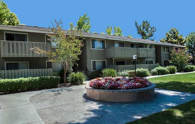 Apartment complex with a flower bed in front.