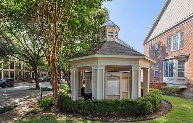 A small white building with a black roof and a sign on the door.