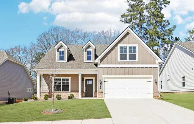 A two-story house with a garage and a driveway.