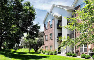 A tree in front of a building with a white balcony. at Tranquility Pointe, Omaha, NE, 68164