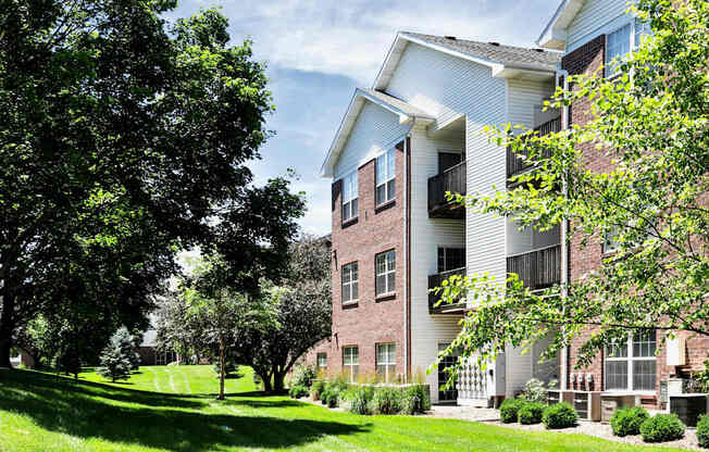 A tree in front of a building with a white balcony. at Tranquility Pointe, Omaha, NE, 68164