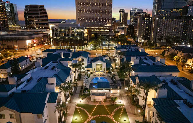 A cityscape at dusk with a lit-up building in the foreground.