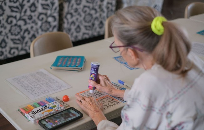 a woman sitting at a table using a calculator on a calculator