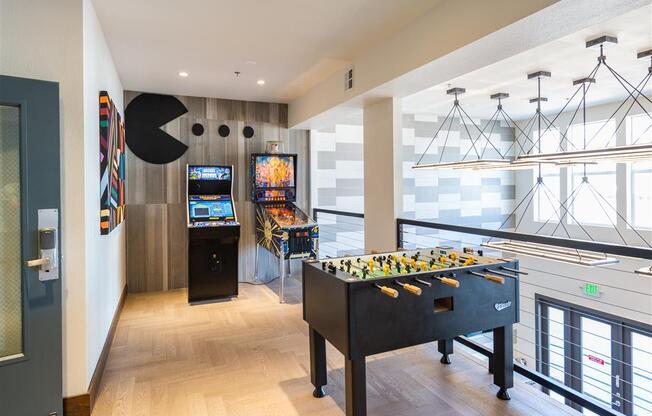 a games room with a foosball table and two arcade games
