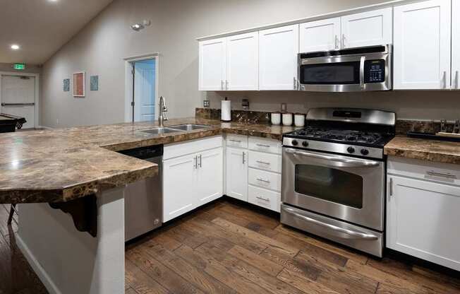 A kitchen with a granite countertop and stainless steel appliances.
