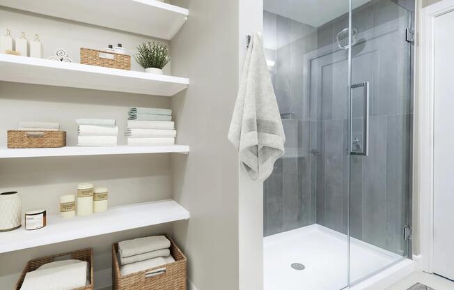 Sleek glass-enclosed showers in select homes offer a spa-inspired retreat with modern finishes and built-in shelving for effortless organization.