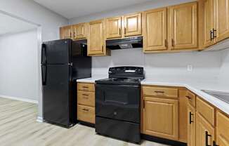 a kitchen with black appliances and wooden cabinets