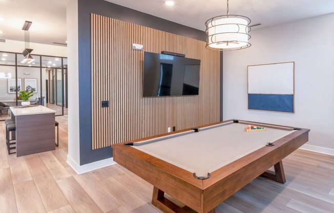 a pool table in a clubhouse with a tv on the wall