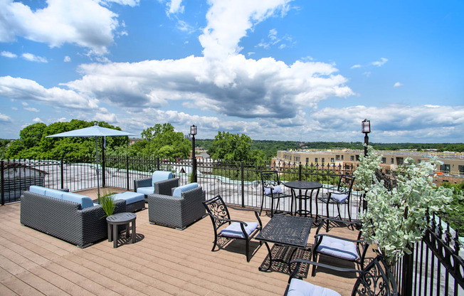a rooftop patio with tables and chairs and a view of the city