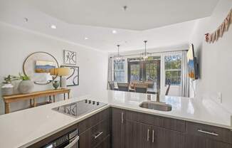 A modern kitchen with dark wood cabinets and a white countertop.