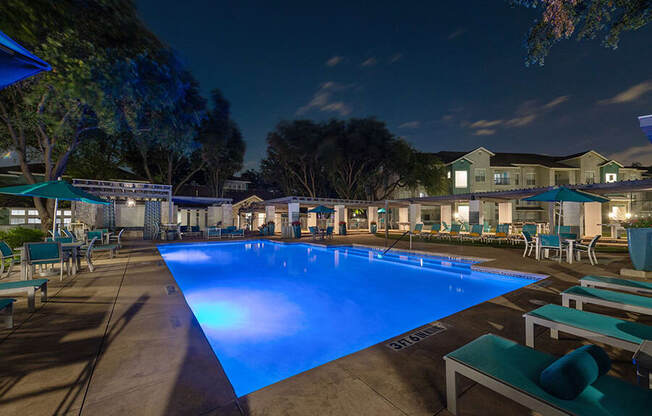 Community Swimming Pool with Pool Furniture at Essence Apartments in Dallas, TX.